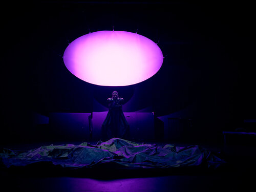 Frau unter hellviolett erleuchtetem Oval