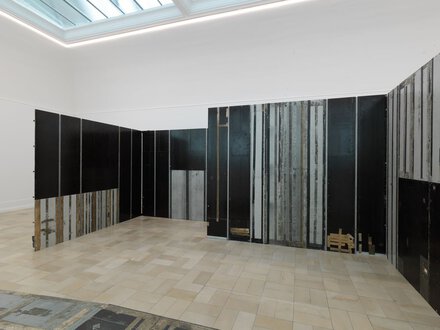Raumfüllende Installation von Michael Pirgelis aus Flugzeugböden, die wie Paravents den großen Ausstellungsraum labyrinthisch teilen.