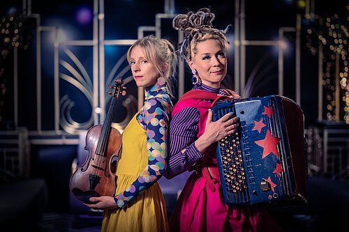 zwei Frauen mit Violine und Akkordeon bunt gekleidet