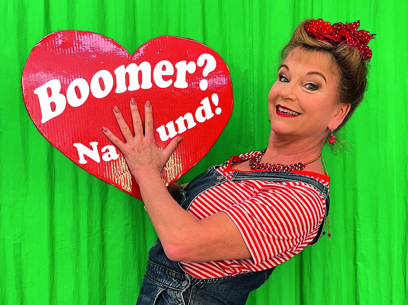 Julia Kempken hält lächelnd ein großes Lebkuchenherz in den Händen, darauf steht: Boomer? Na und!