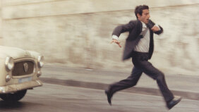 Ein Mann rennt und wird von einem Auto verfolgt - Szenenbild aus dem Film Z - Anatomie eines politischen Mordes