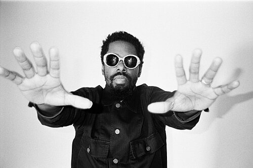 Ein Mann mit Sonnenbrille streckt seine Hände aus 