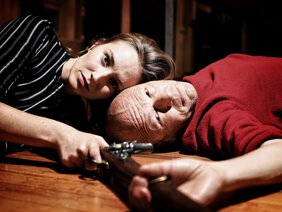 Lisa Ahorn und Achim Conrad liegen Kopf an Kopf auf dem Boden, ein Gewehr in der Hand