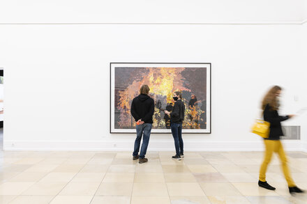 Foto, aufgenommen während der Eröffnung der Ausstellung Es brennt mit Werken von Marcel Odenbach. Zu sehen ist die Collage Es brennt.