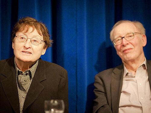 Erika und Ulrich Gregor sitzen vor einem blauen Vorhang