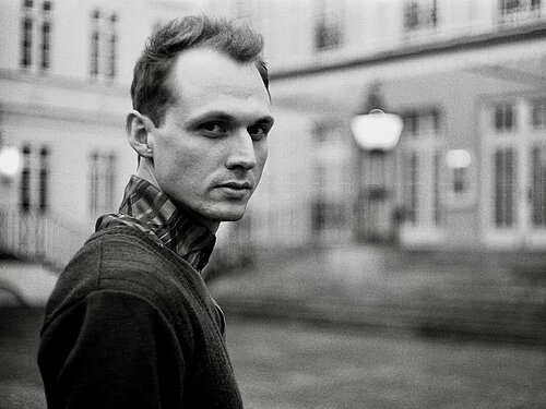 Junger Mann blickt seitlich zurück, schwarz weiß