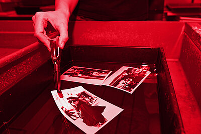 Wässerung von frisch entwickelten Fotos im Rotlicht