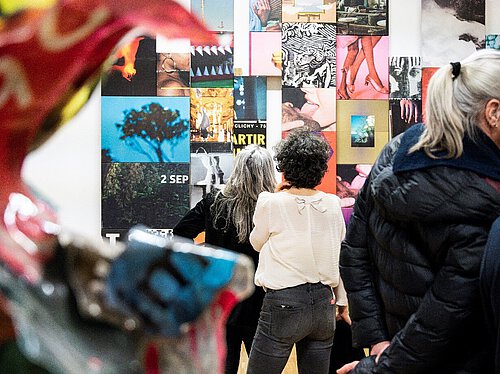 Frauen von hinten in einer Ausstellung