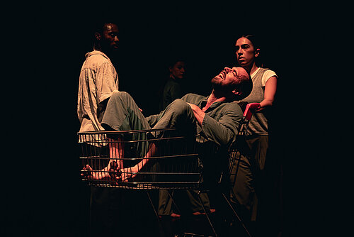 ein Mann wird von einer Frau in einem Einkaufswagen geschoben