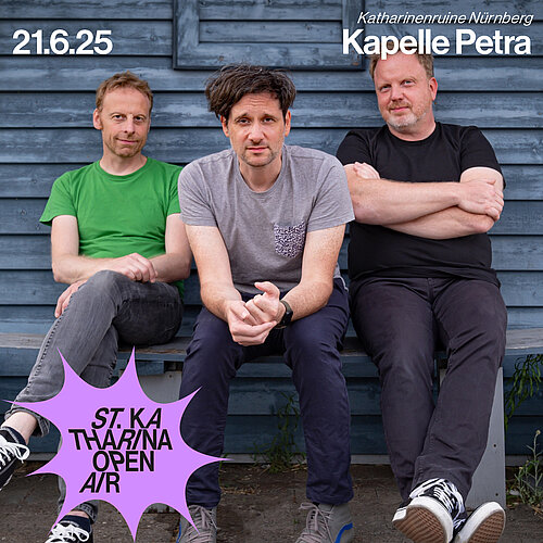 Drei Männer sitzen mit Blick zur Kamer auf einer Bank vor einer blauen Holzwand. 