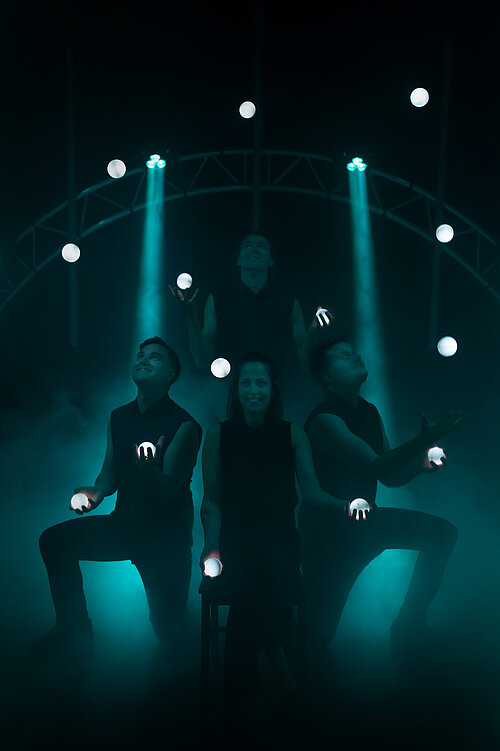 Menschen jonglieren mit leuchtenden Kugeln