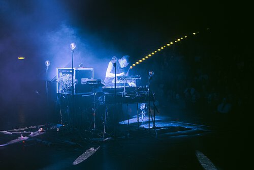 Mann an Musikpult in blauem Licht