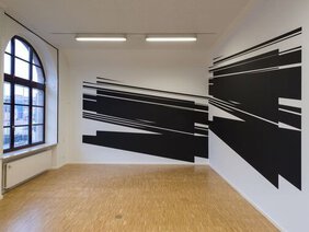 Schwarze, abstrakte Wandmalerei, die in den Raum hineinzuragen scheint