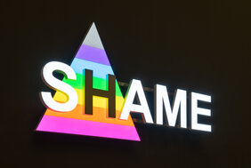 Videostill der Projektion von Jens Pecho, die abwechselnd die Worte Shame beziehungsweise Same zeigt