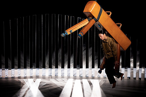 Frau hängt unter schwebendem Pauschenpferd