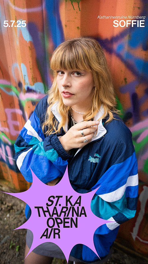 eine junge Frau vor einem bunt angesprühten Container + Konzerttermin 05.07.