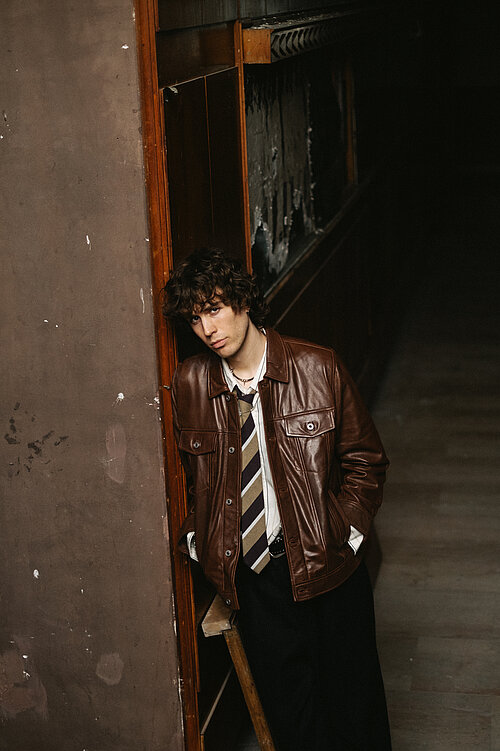 ein junger Mann an eine Wand gelehnt