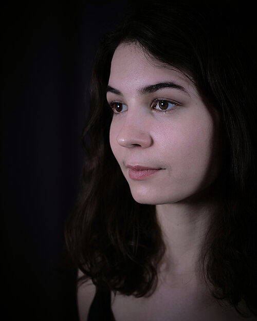 seitliche Nahaufnahme einer Frau mit dicken dunklen Haaren