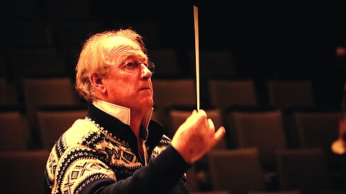 ältere Mann mit Dirigenten-Stab