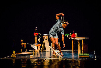 Schauspielerin auf der Bühne bückt sich nach rechts