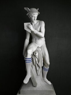 Foto von Elmgreen & Dragset zeigt eine Skulptur des Götterboten Merkur mit Kniestrümpfen