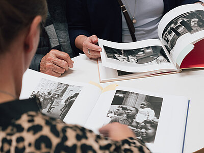 Besuchende beim Blättern in den Katalogen