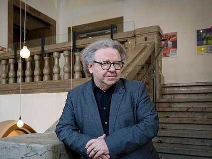 Mann mit Anzug in einem historischen Treppenhaus