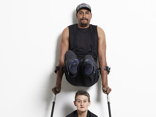 Zwei Tänzer*innen vor weißem Hintergrund