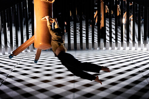 Frau hängt an schwebendem Pauschenpferd