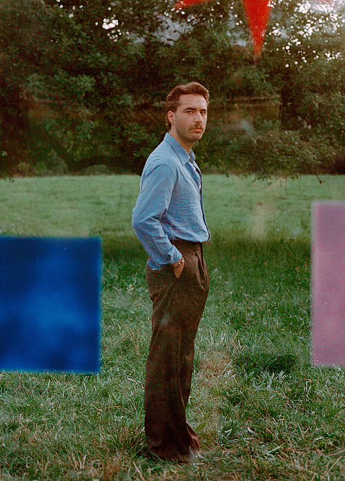 Ein Mann steht auf einer Wiese