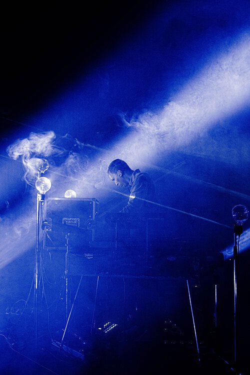 Mann an Musikpult in blauem Licht