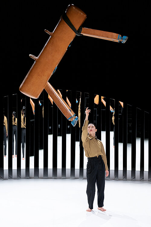 Frau steht unter schwebendem Pauschenpferd