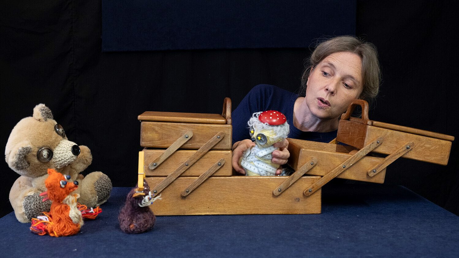 Das Bild zeigt ein Nähkästchen in dem die Figuren des Puppentheaters zum Leben erwachen - ein Bär, ein Fuchs,...