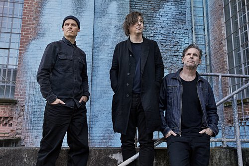 drei Männer in schwarz gekleidet an Gerüst