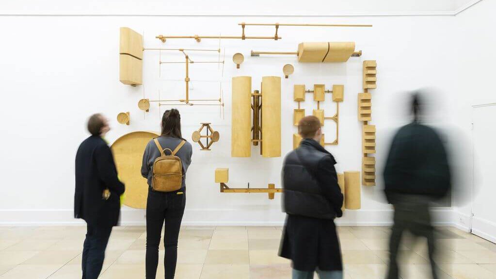 Eine Wandinstallation aus hölzernen Nachbauten von Antennen und Transmitterverschalungen in der Ausstellung von Oliver van den Berg