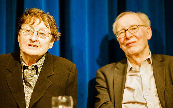 Erika und Ulrich Gregor sitzen vor einem blauen Vorhang