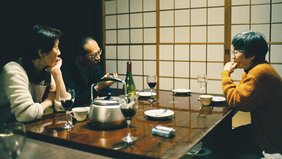 Szenenbild aus dem Film The Works And Days Of - eine japanische Familie sitzt an einem Tisch vor einer Wandbespannung aus Reispapier