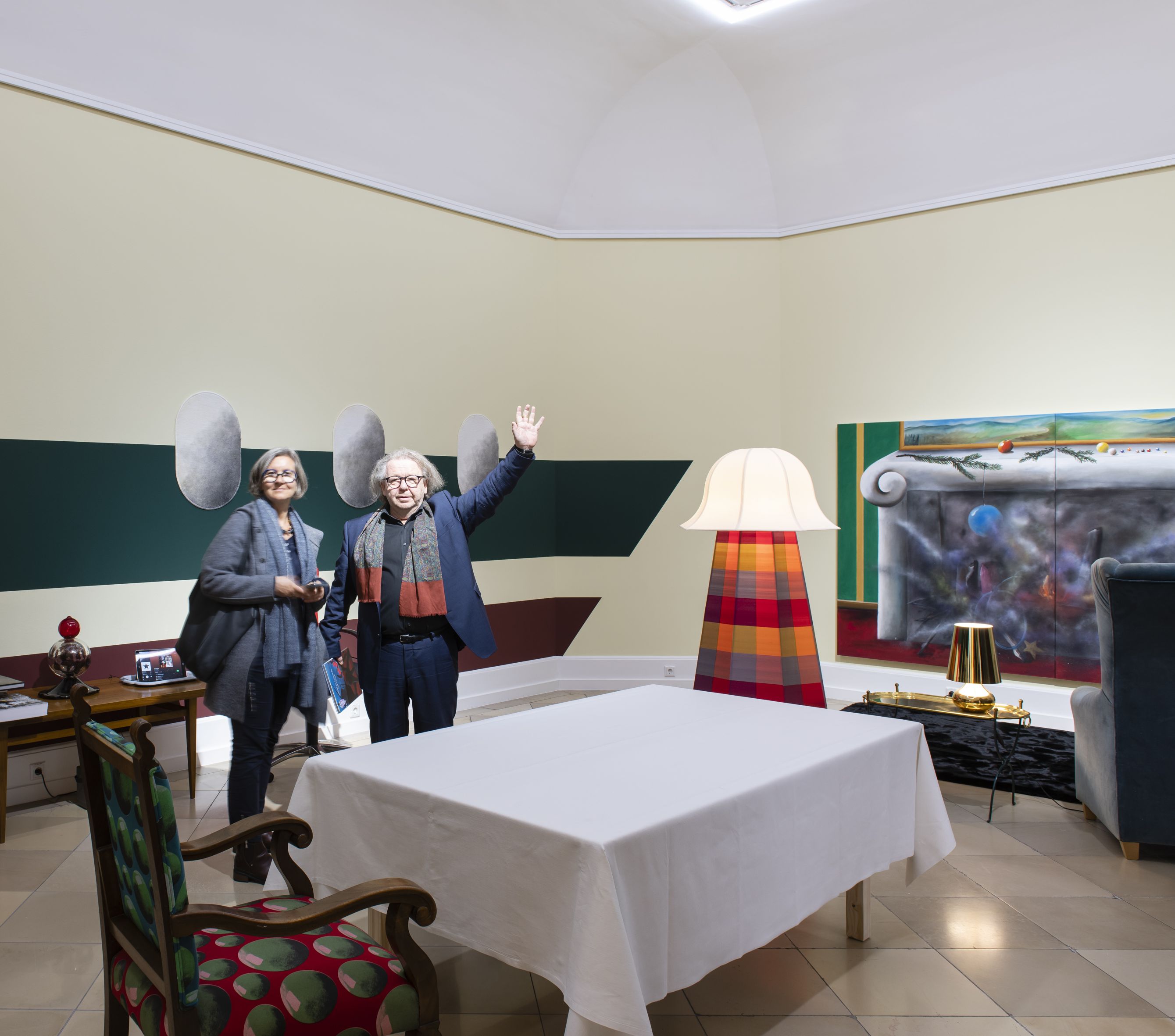 Winkender Mann und Frau in einer Kunstausstellung.