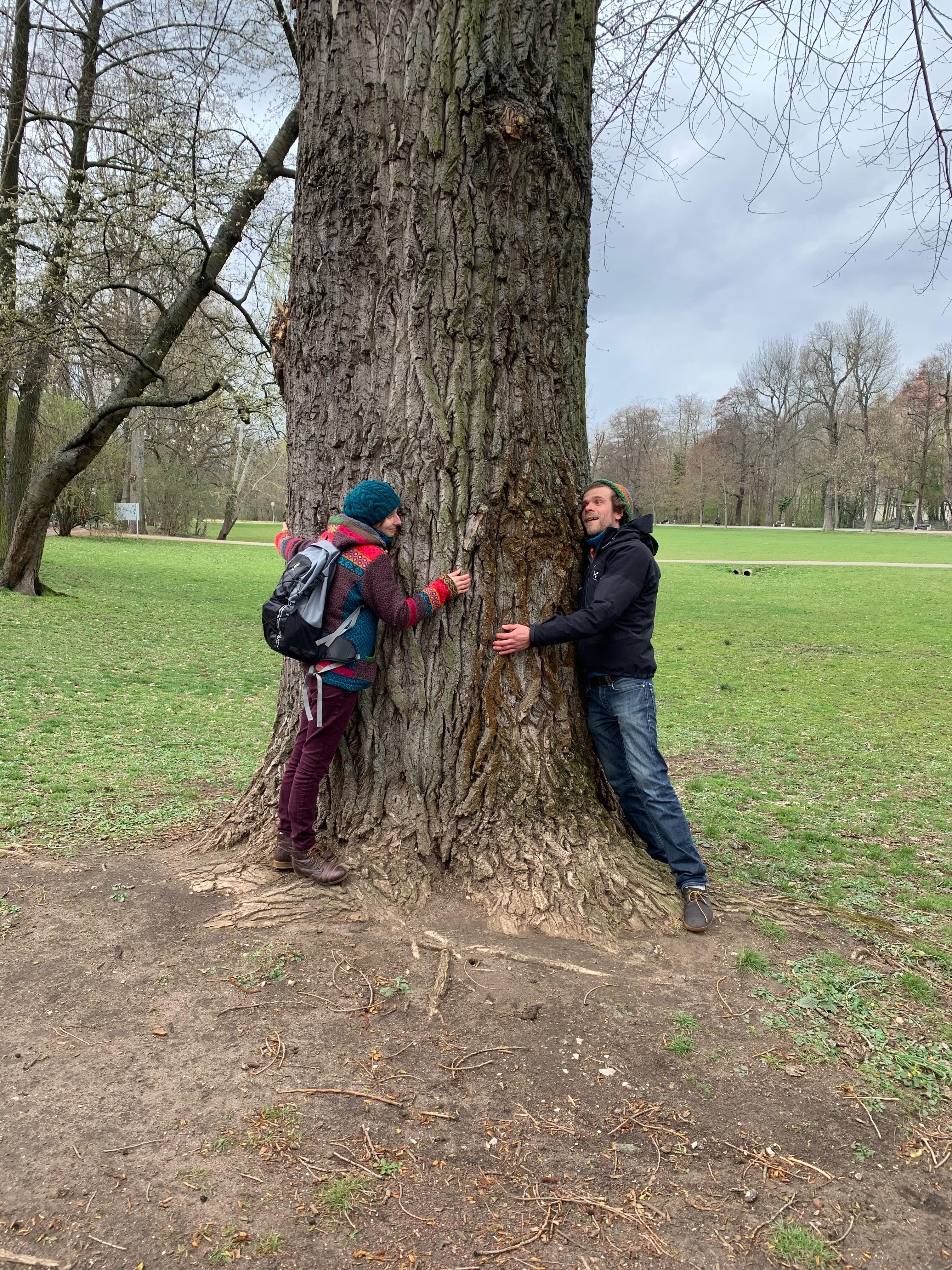 Zwei Personen umarmen einen Baum