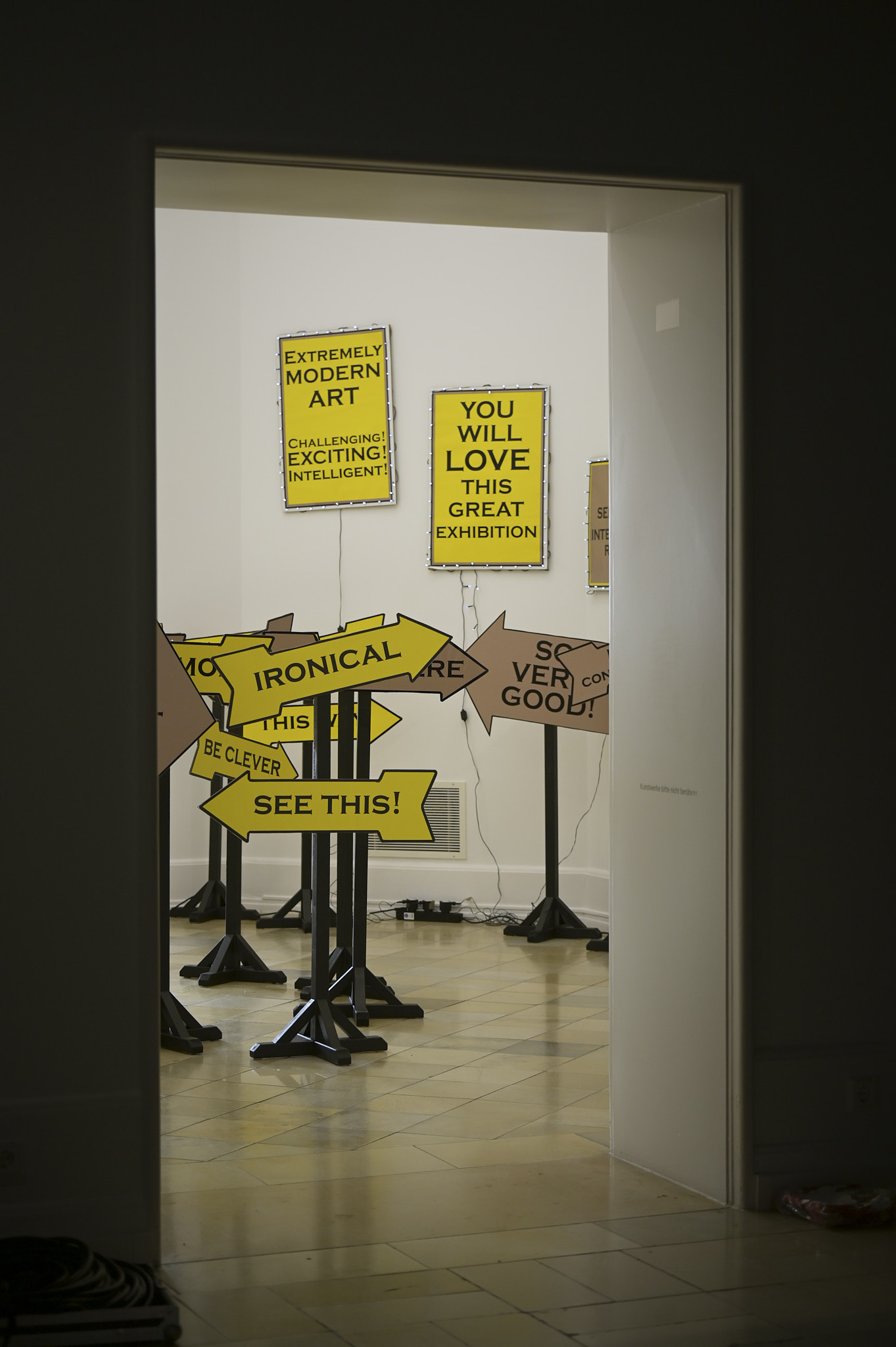 Martkschreierischer Schilderwald mit Slogans, die die Ausstlellung in Superlativen anpreisen