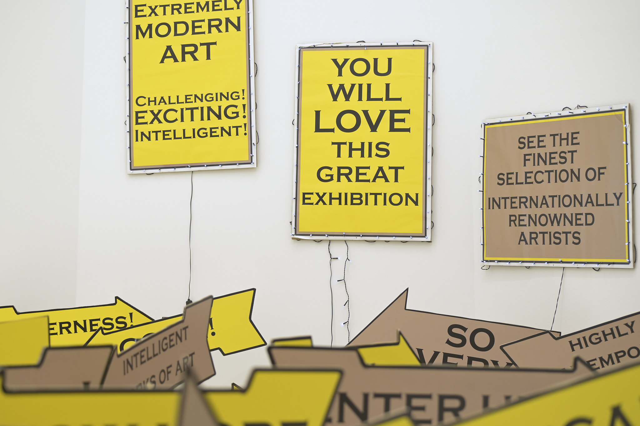 Martkschreierischer Schilderwald mit Slogans, die die Ausstlellung in Superlativen anpreisen