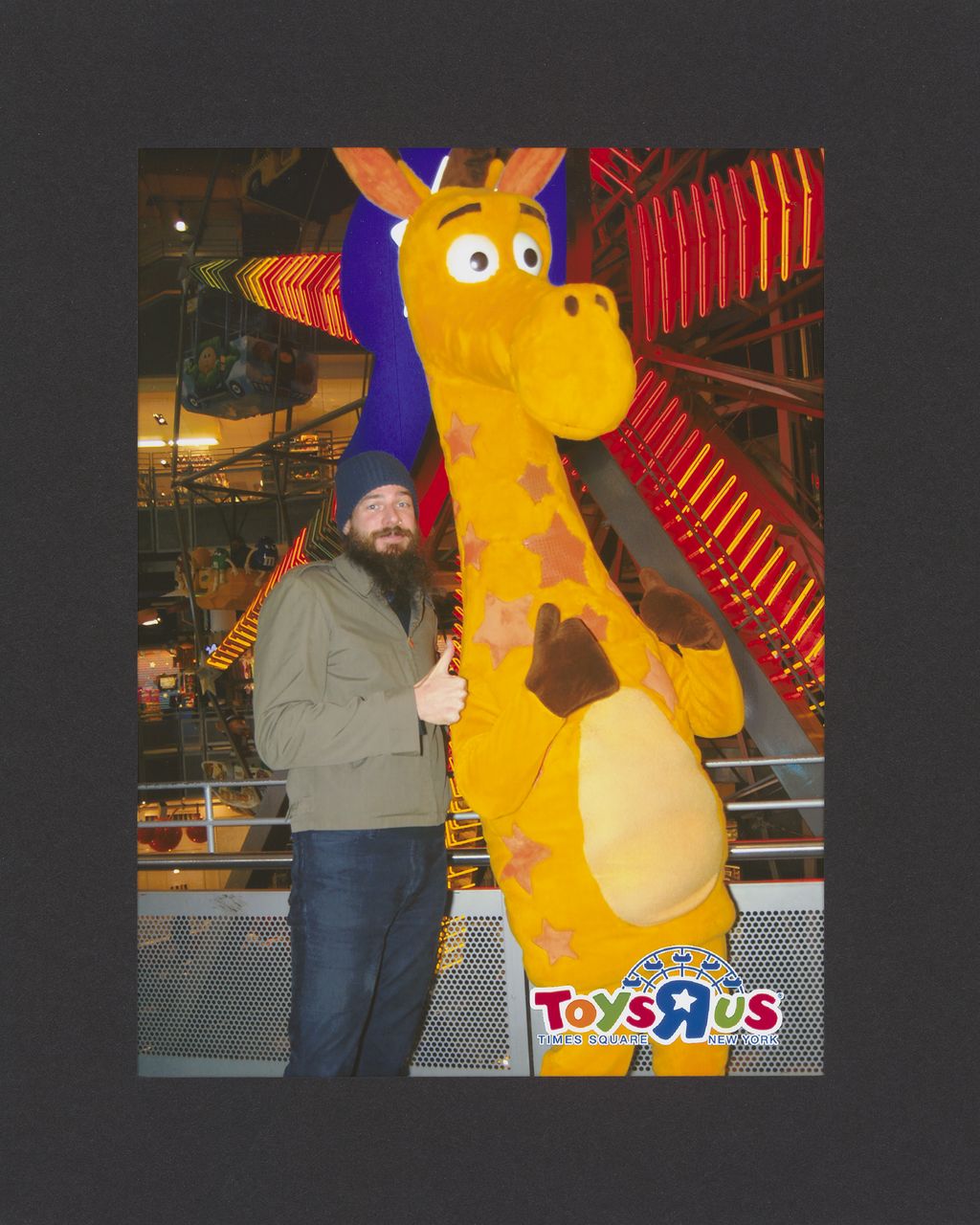 Foto des Künstlers zusammen mit dem Maskottchen der Spielwarenmarke Toys R us.