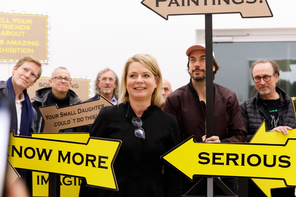 Große gelbe Pfeile bewerben die Ausstellung mit den Schlagworten z.B. Serious, Painting, Know More und ähnliche Slogans