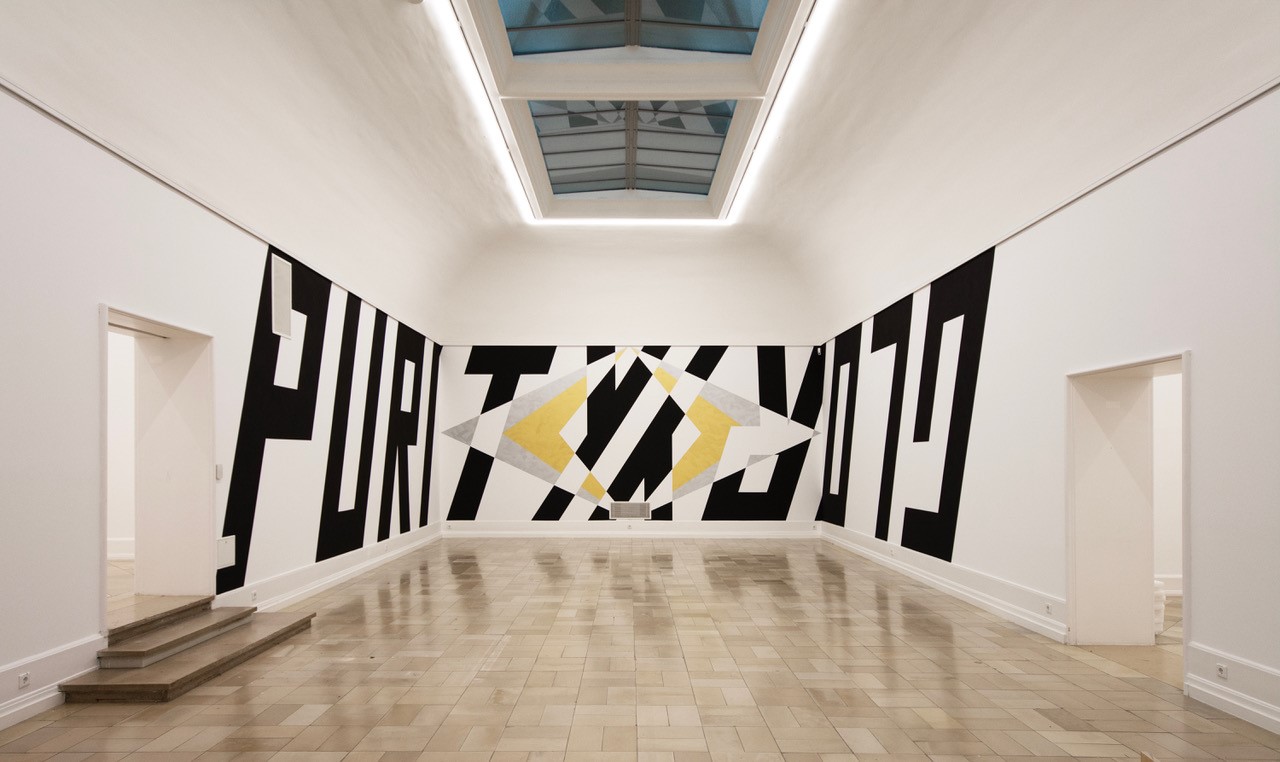 Die Worte Purity und Glory in schwarzer Schrift wandfüllend aufgemalt