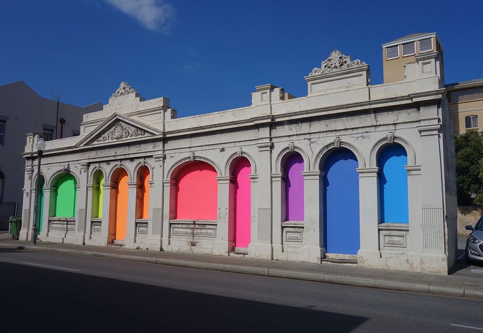 Rundbogenfenster mit farbigen Fensterscheiben in Blau, Rot, Orange und Grün 