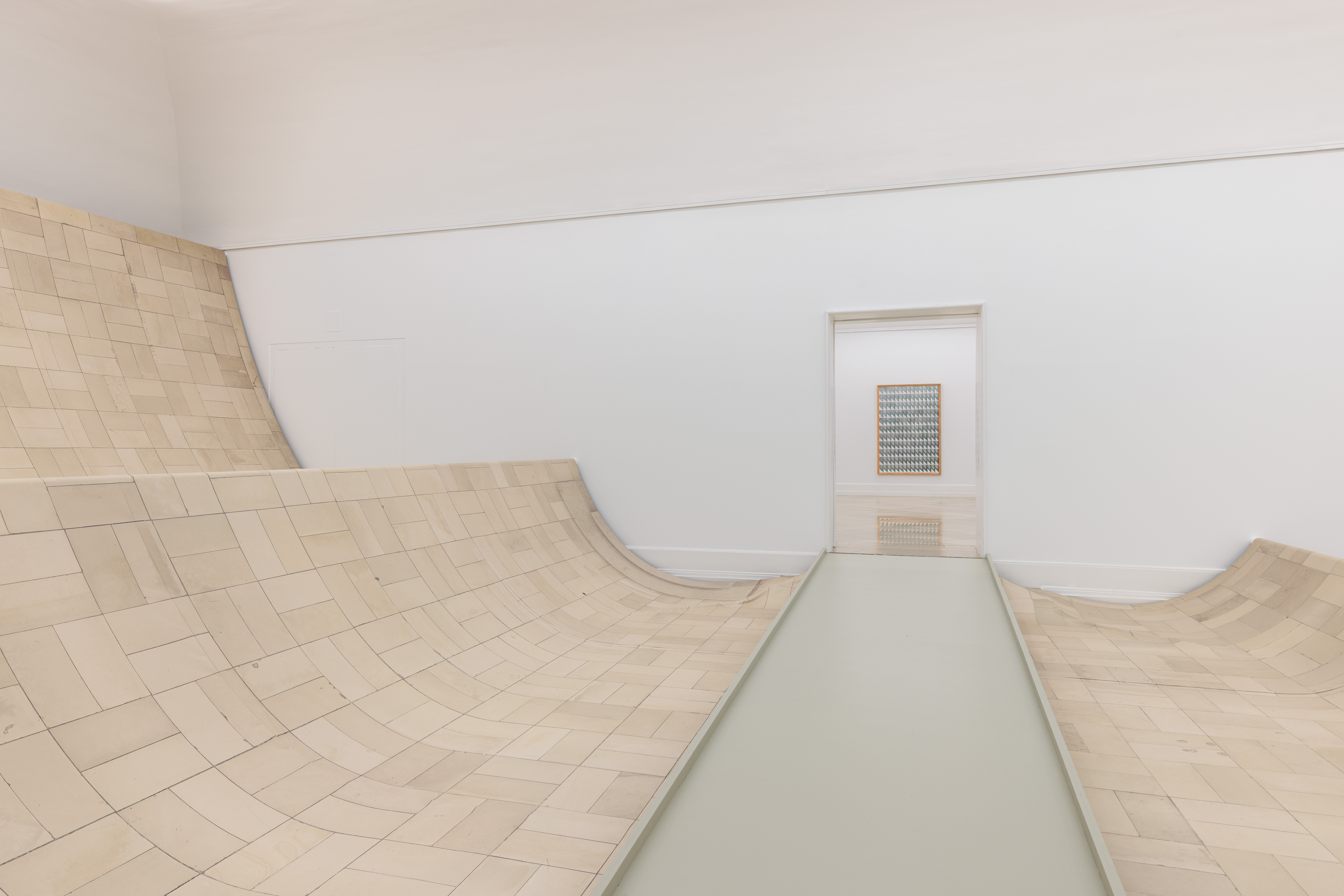 Die Installation aus Stoff immitiert den Fußboden des Raumes. Der Stoff verläuft wellenartig durch den Raum und an der Stirnseite die Wand hinauf.