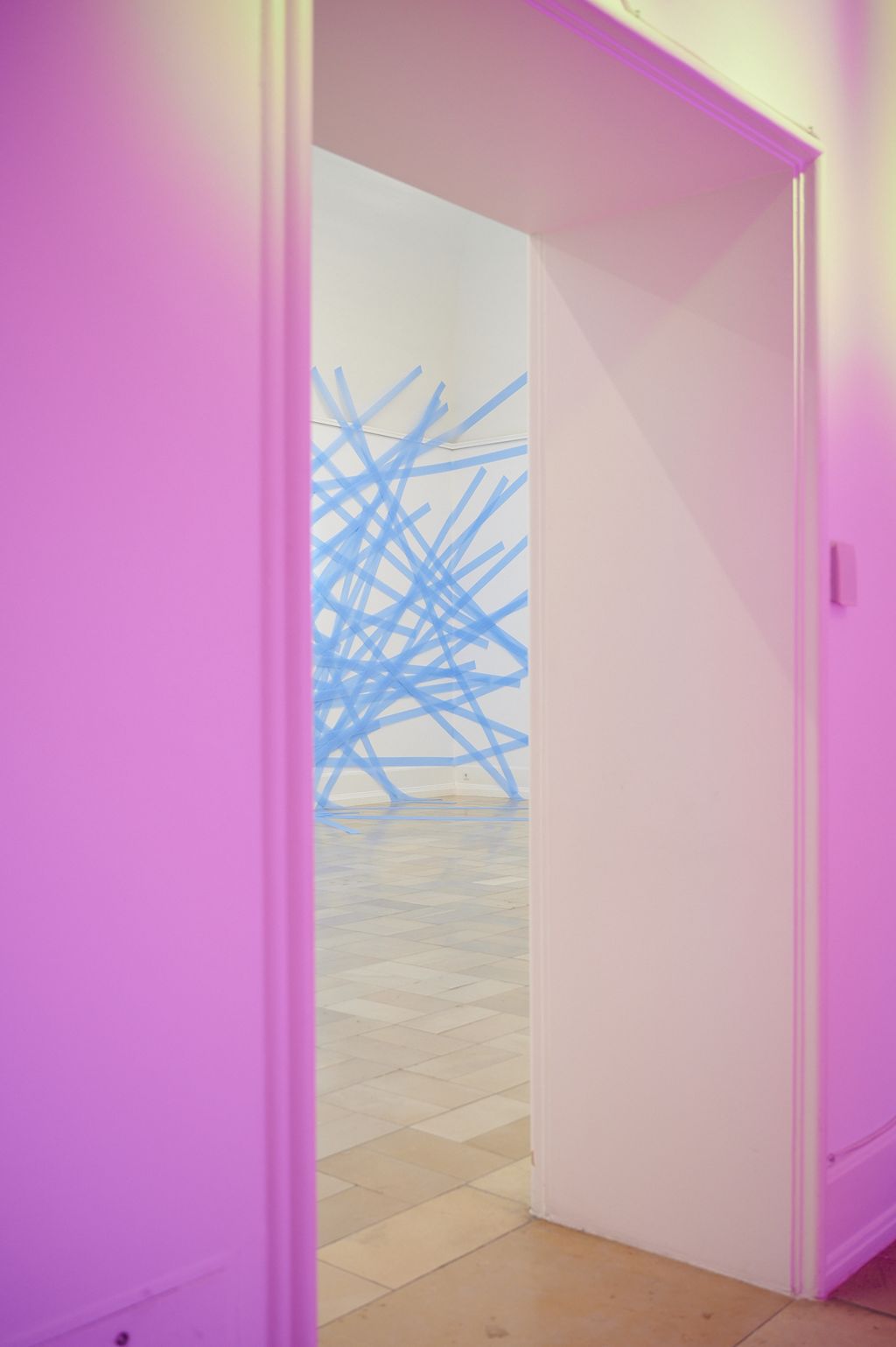 Blick aus dem pinkfarbenem Lichtraum von Zora Kreuzer auf die Wandarbeit aus blauen Dämmstreifen von Kirstin Arndt