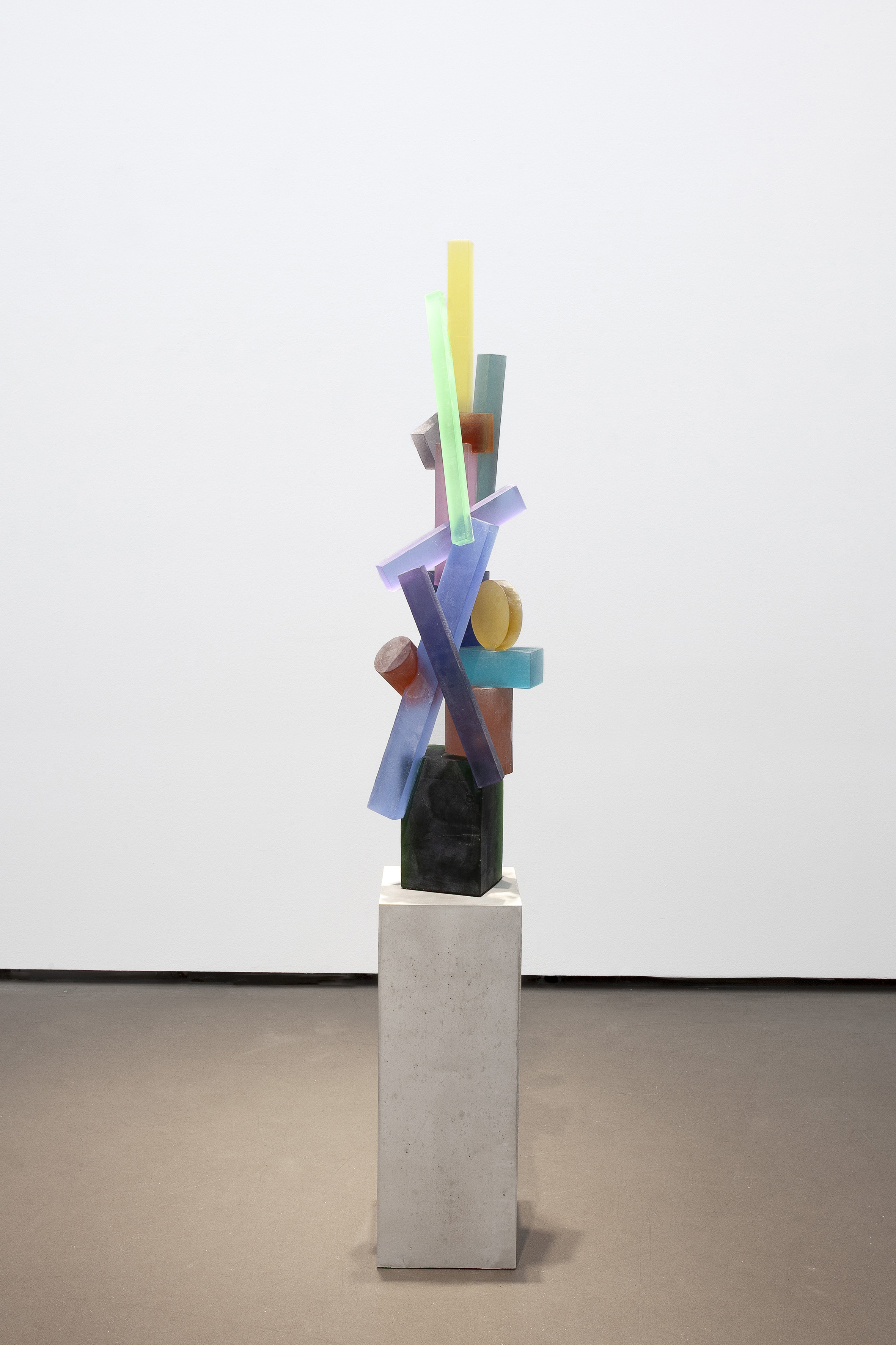 Vertikale buntfarbige Glasskulptur, zusammengesetzt aus farbigen Stäben und Scheiben.