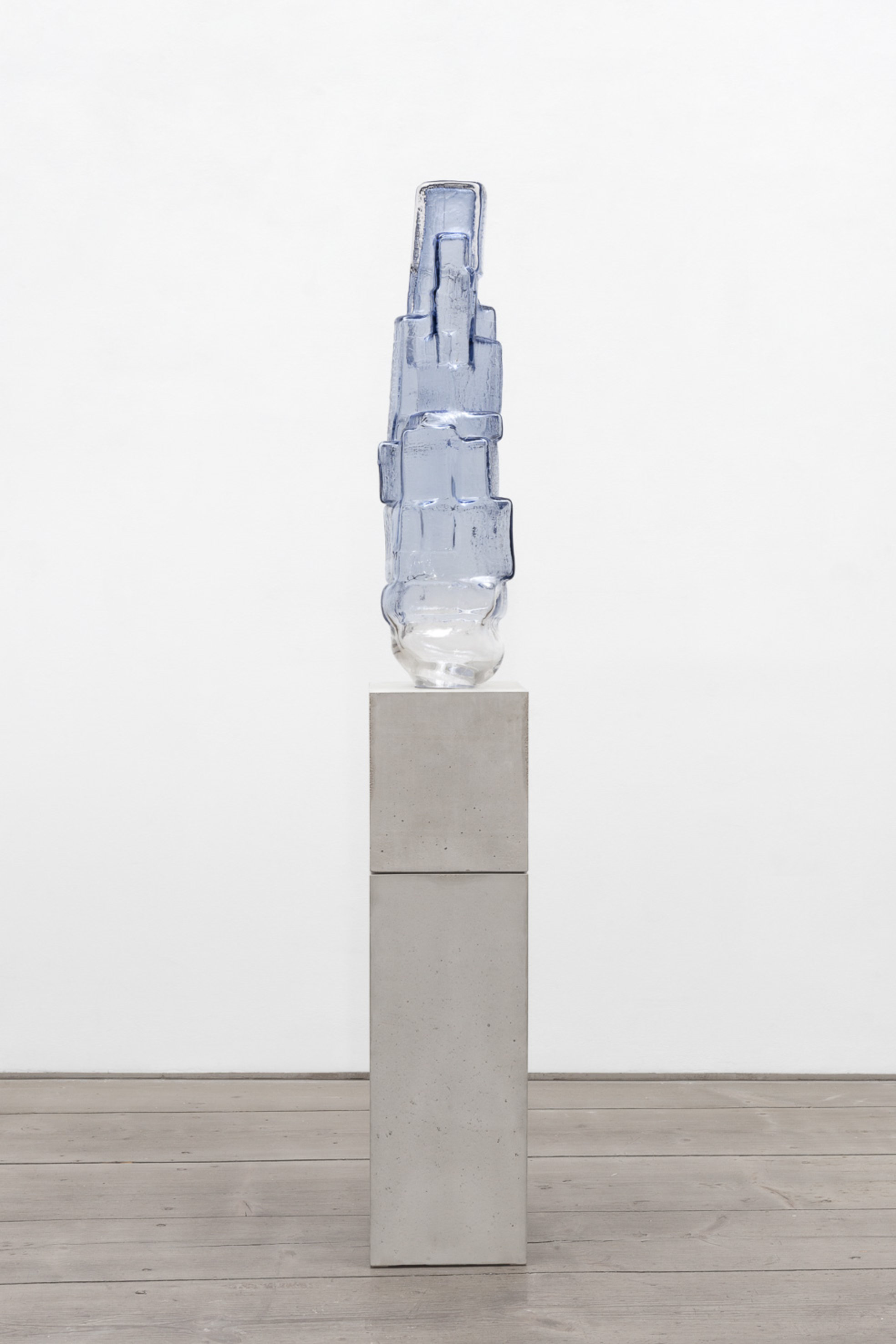 Vertikale Glasskulptur mit einem durchscheinenden Farbverlauf von Blau bis zu farblosem Klarglas 