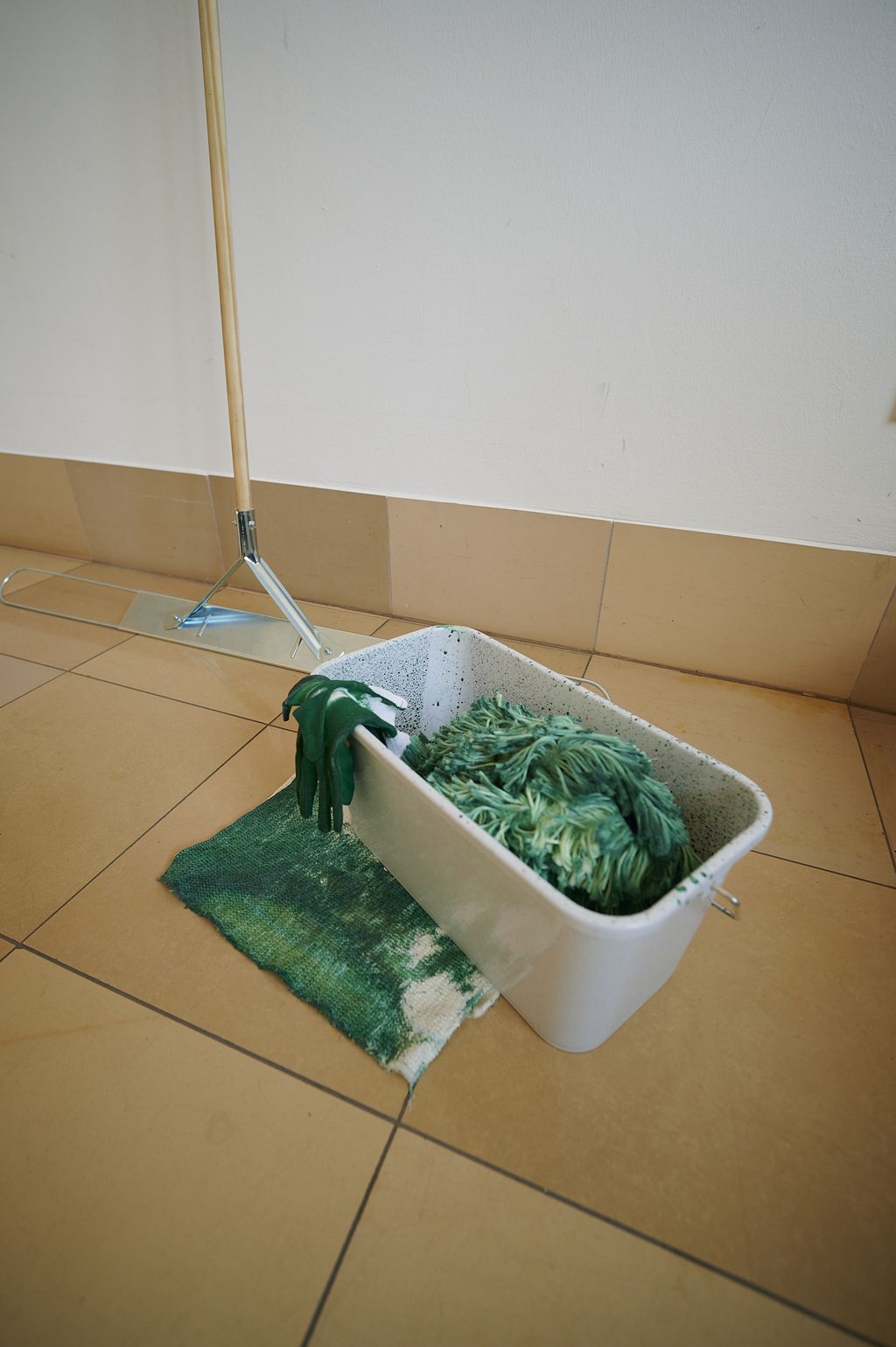 Ein Putzeimer, ein Wischer mit Putzlappen, ein verschmutzer Putzlappen, alle Utensilien mit deutlichen Gebrauchsspuren